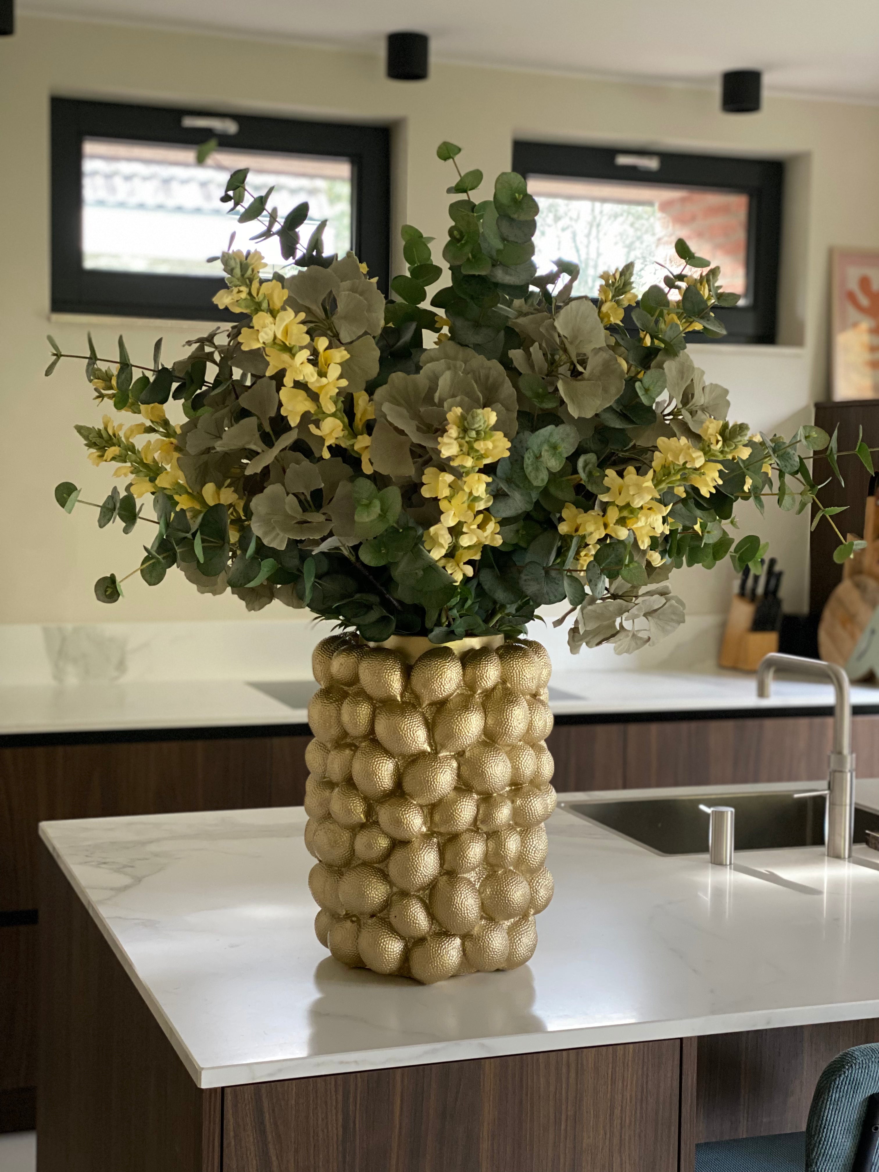 Citroenenvaas met kunstbloemen in keuken